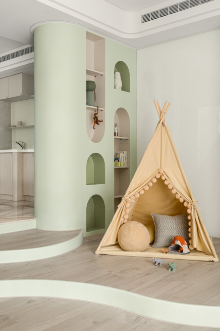 親子住宅客廳設計，弧形牆面與窗邊座位形塑放鬆的生活場景